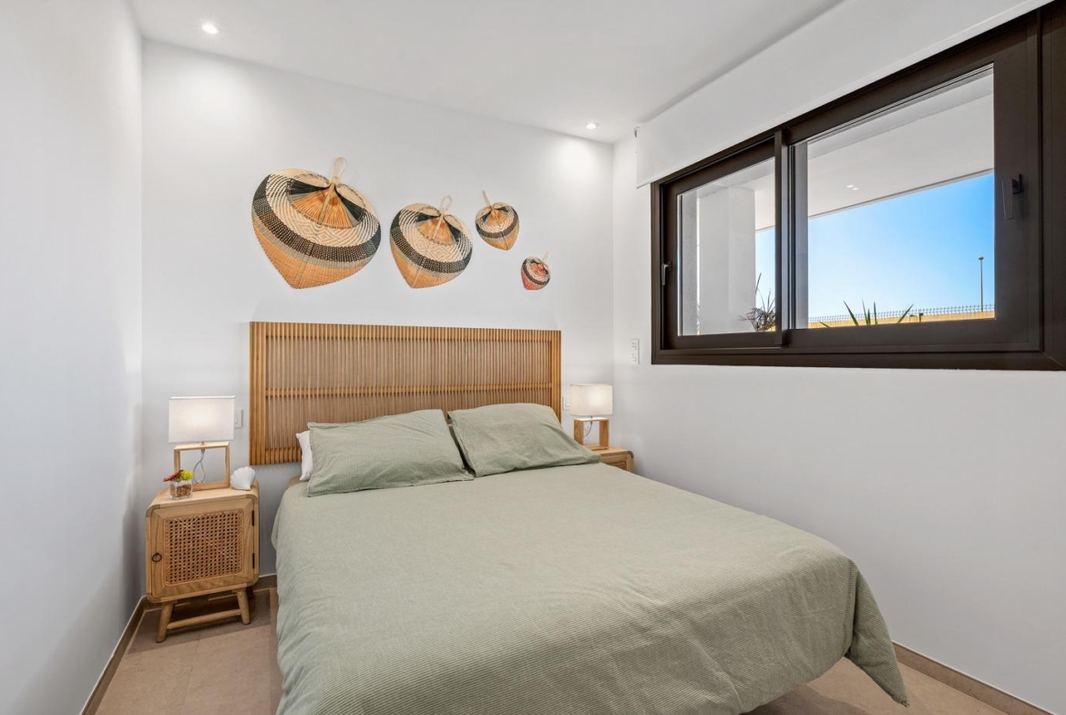 Bright and modern 2-bedroom ground floor apartment bedroom with natural light and stylish decor in Serena Golf, Los Alcazares.