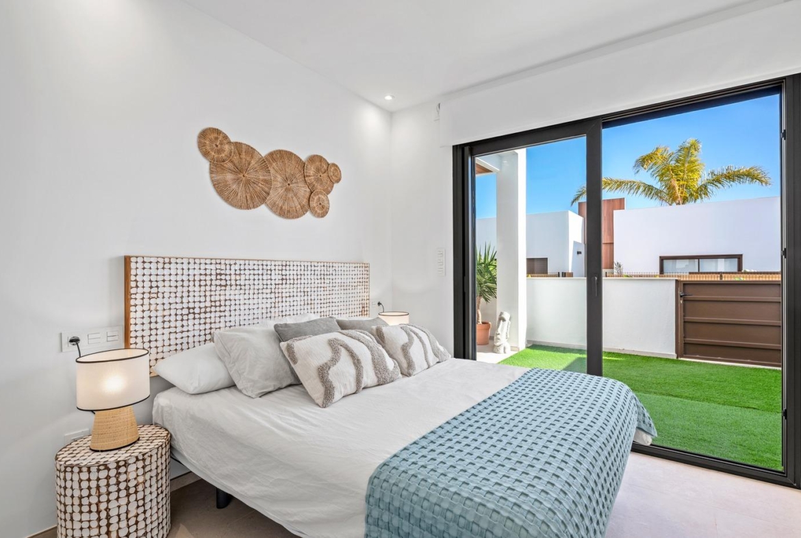 Bright, modern 2-bedroom first floor apartment bedroom with sliding glass doors opening to a sunny terrace in Serena Golf, Los Alcazares
