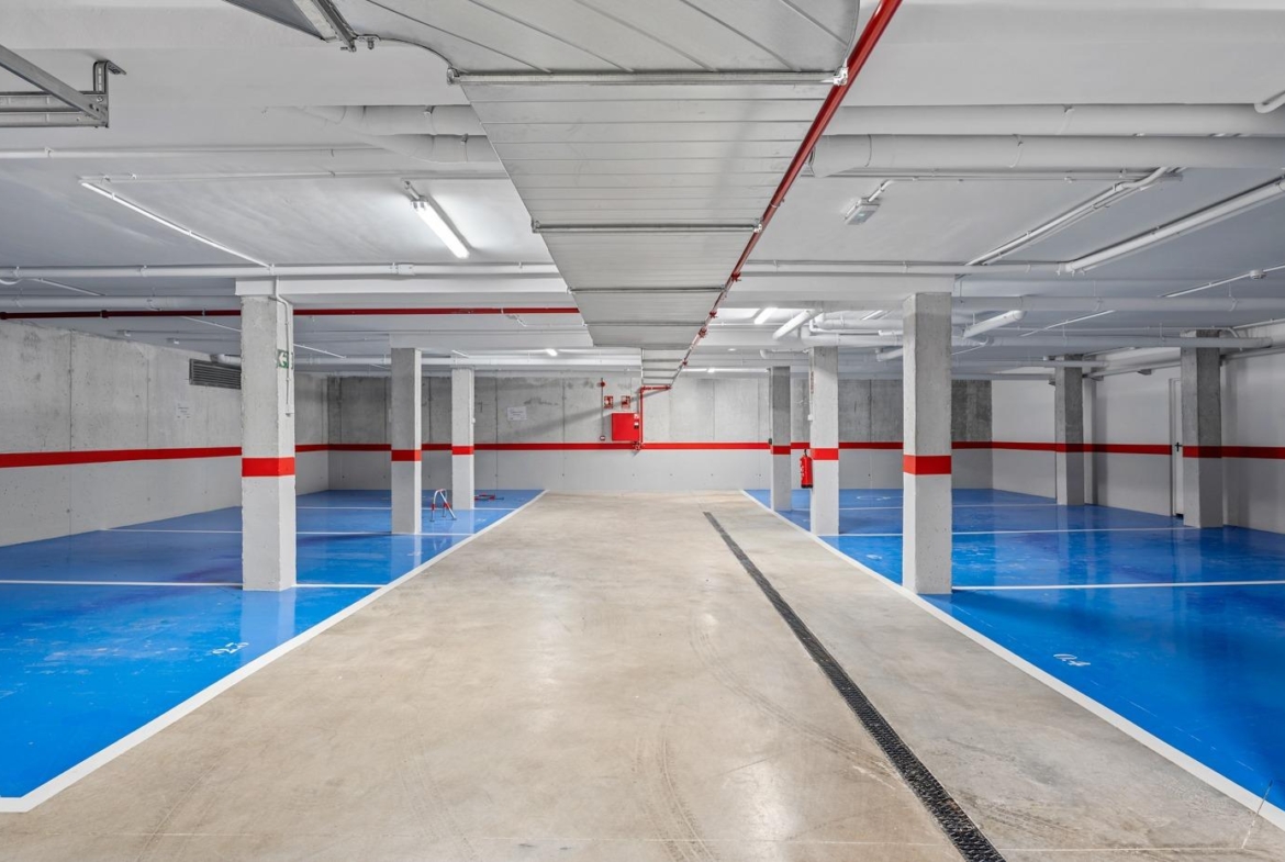 Spacious modern underground parking with bright blue accents for the 2-bedroom ground floor apartment in Serena Golf, Los Alcazares