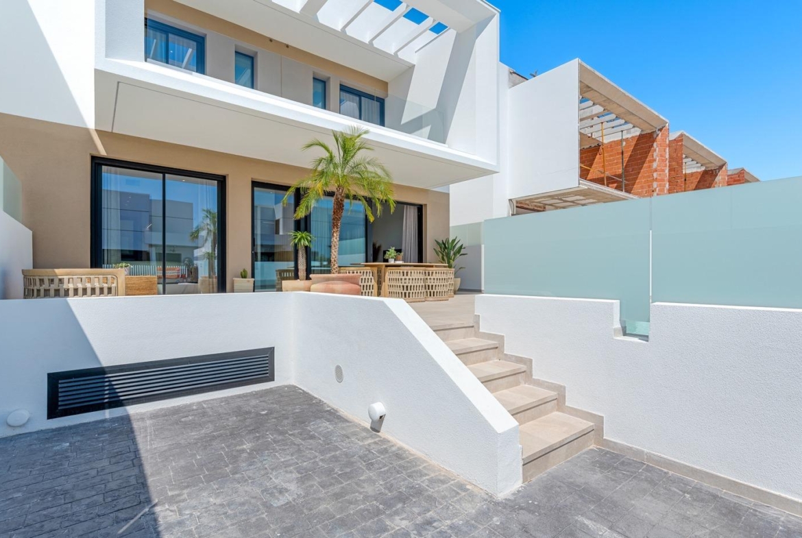 Modern spacious 3-bedroom semi-detached villa exterior in Dolores, Alicante with sunlit terraces and elegant architectural details.
