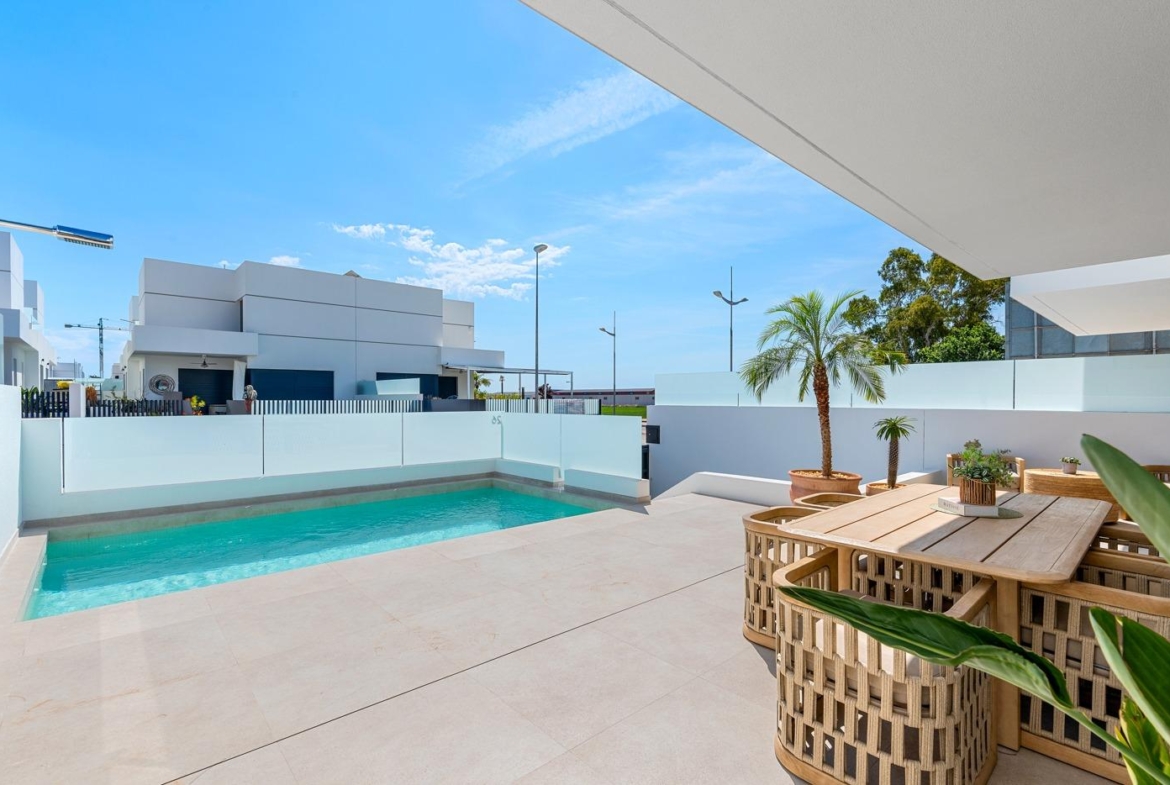 Sun-drenched terrace with private pool and modern outdoor dining area in spacious 3-bedroom semi-detached villa, Dolores Alicante.