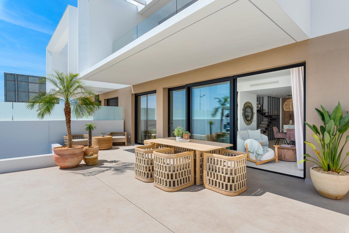 Sun-drenched spacious terrace with modern outdoor dining area at a new build 3-bedroom villa in Dolores, Alicante.