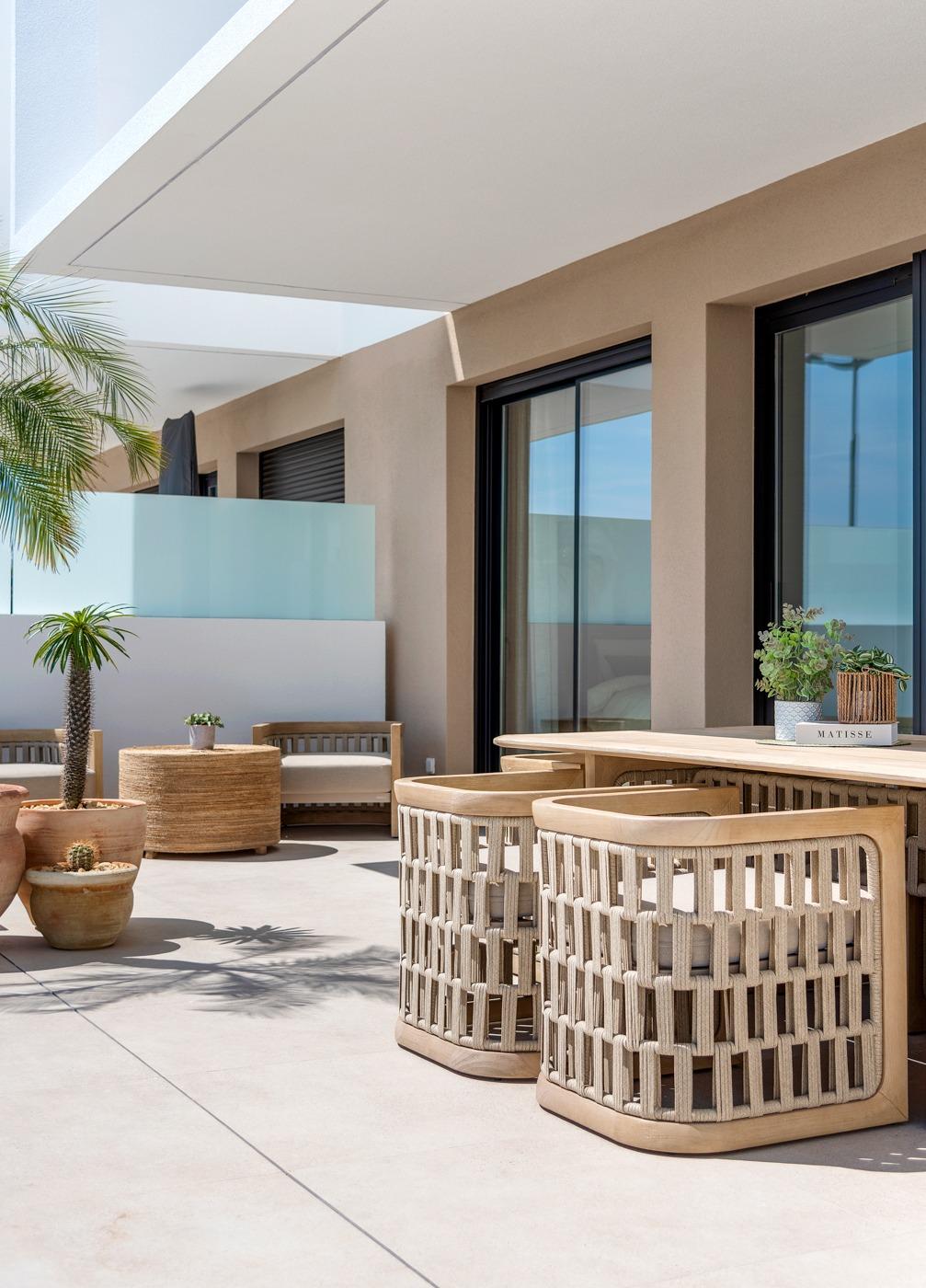 Sunlit modern terrace with stylish wicker furniture in a spacious 3-bedroom semi-detached villa, Dolores, Alicante.