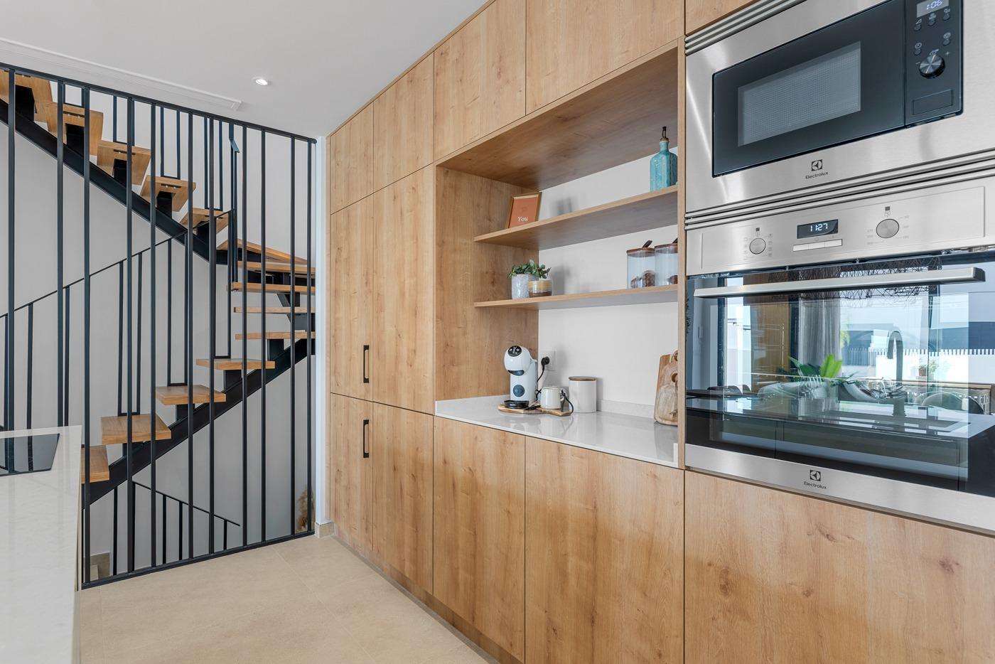 Modern, sleek kitchen with wood cabinetry and built-in appliances in spacious 3 bedroom semi-detached villa, Dolores, Alicante.