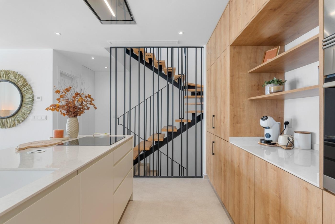 Modern bright kitchen with sleek cabinetry and staircase in spacious 3-bedroom semi-detached villa in Dolores, Alicante.