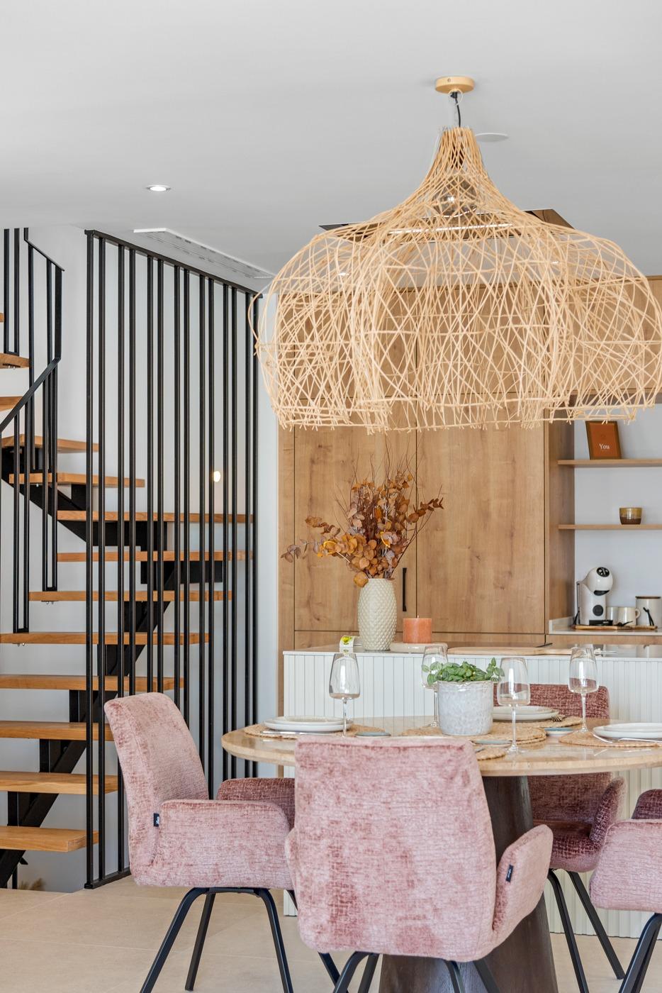 Elegant open-plan dining area with pastel velvet chairs and modern staircase in spacious 3-bedroom villa, Dolores, Alicante.
