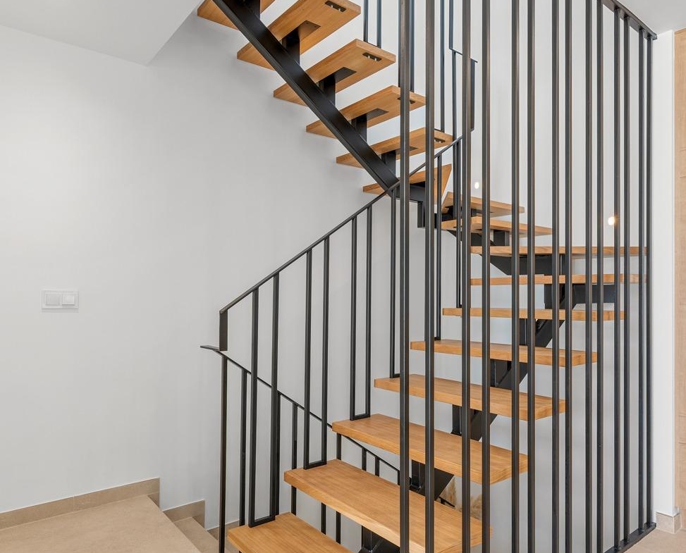 Modern open staircase with sleek wood steps and black metal railing in spacious new build 3-bedroom villa in Dolores, Alicante