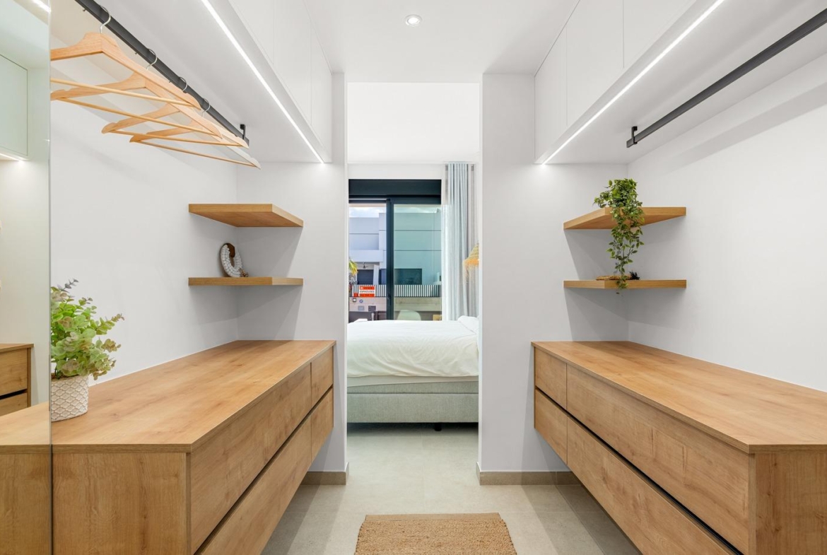 Bright modern walk-in closet with wooden drawers and shelves in spacious 3-bedroom semi-detached villa in Dolores, Alicante