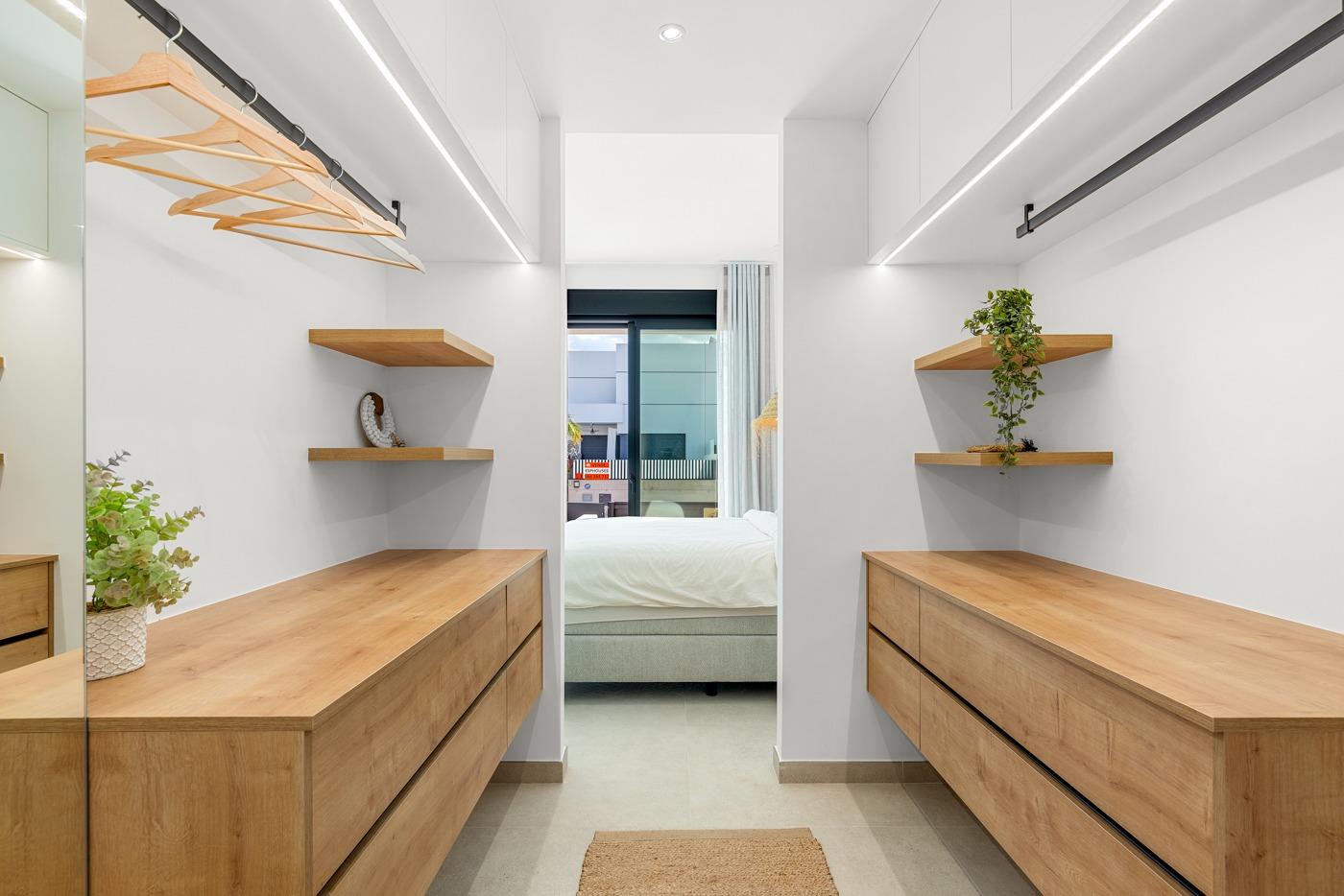 Bright modern walk-in closet with wooden drawers and shelves in spacious 3-bedroom semi-detached villa in Dolores, Alicante