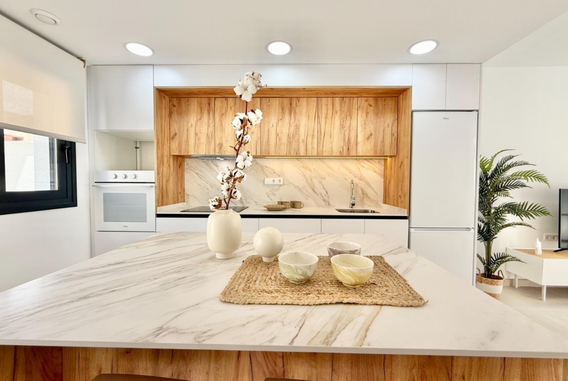 Bright modern kitchen with sleek marble countertops and wood accents in new 2-bedroom townhouse in Cox, Alicante.