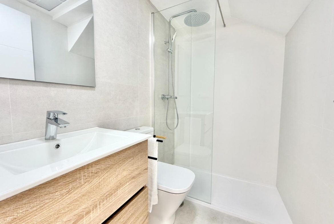 Bright modern bathroom with sleek wooden vanity and rain shower in spacious new build 3-bedroom townhouse in Cox, Alicante