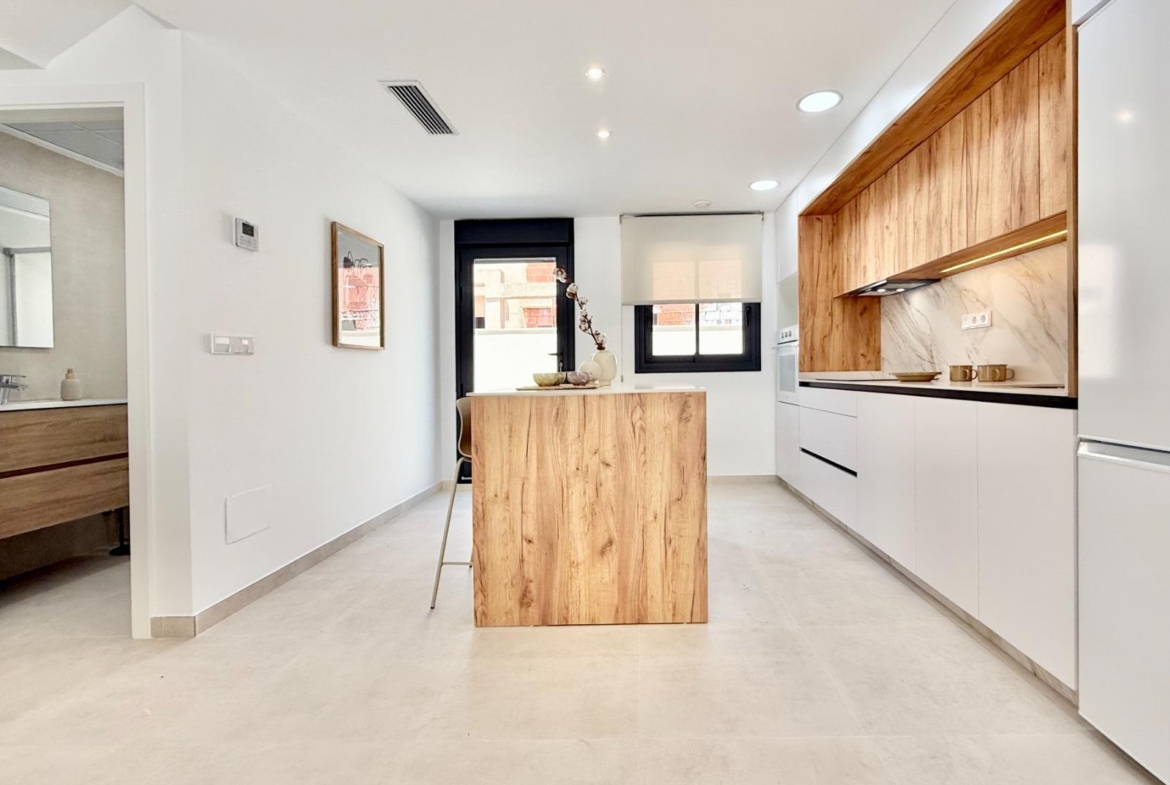 Bright modern kitchen with sleek wood accents in affordable 2-bedroom townhouse in Cox, Alicante new build development.