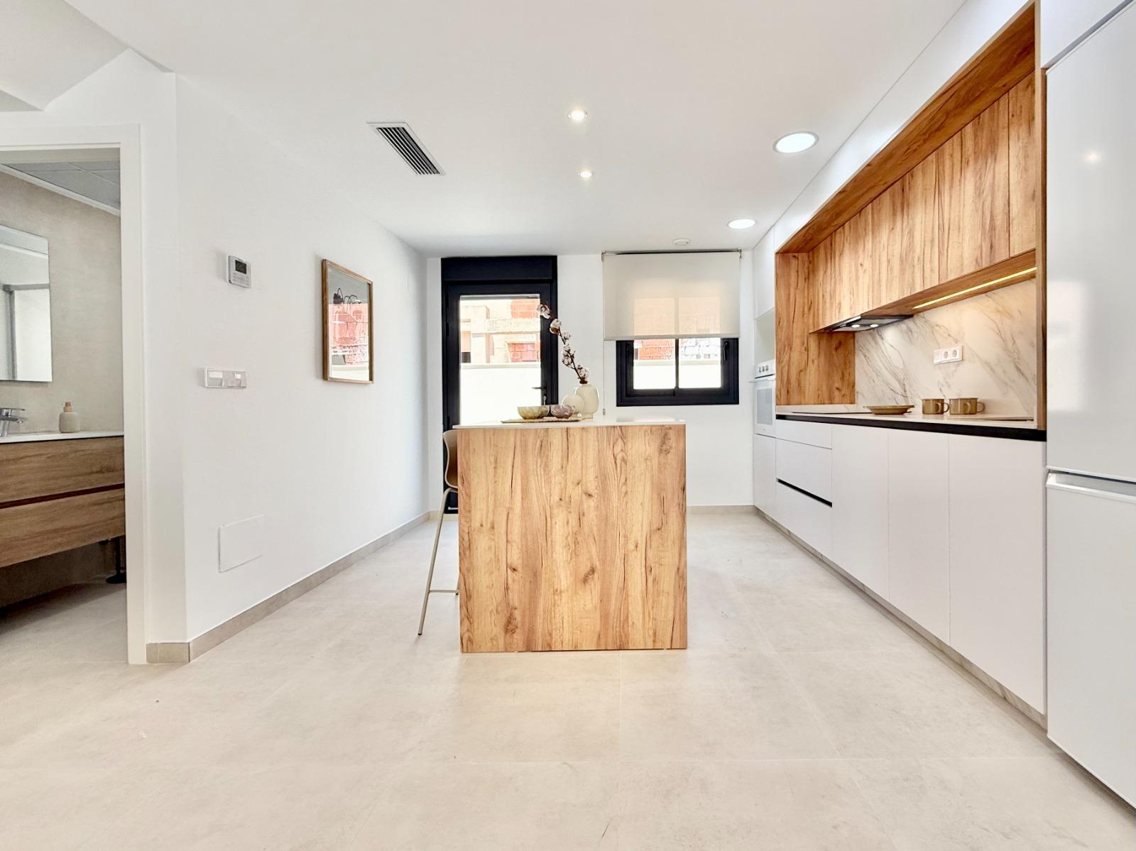 Bright modern kitchen with sleek wood accents in affordable 2-bedroom townhouse in Cox, Alicante new build development.
