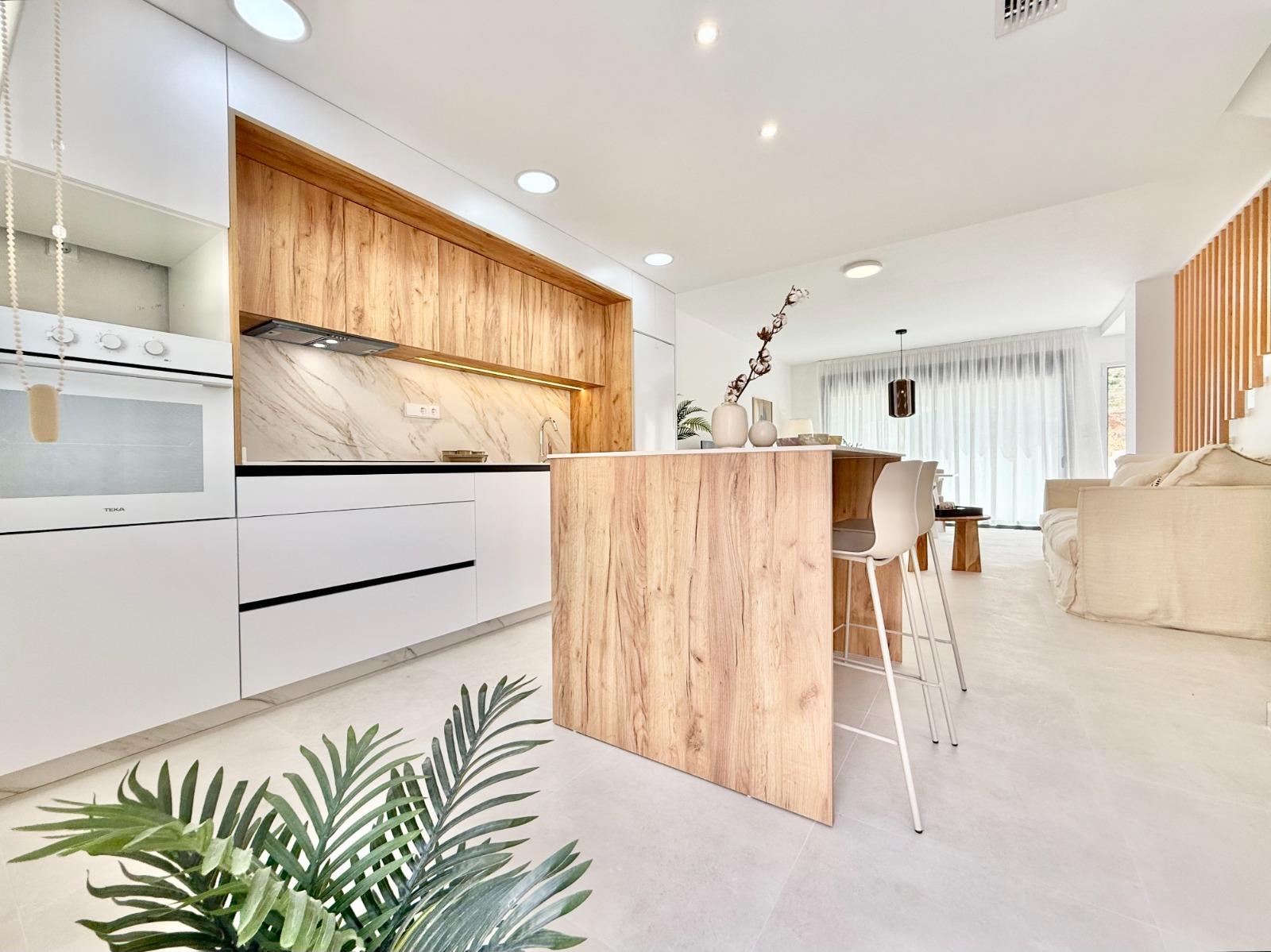 Bright modern kitchen with wood accents and open-plan living in affordable 2-bedroom townhouse in Cox, Alicante.