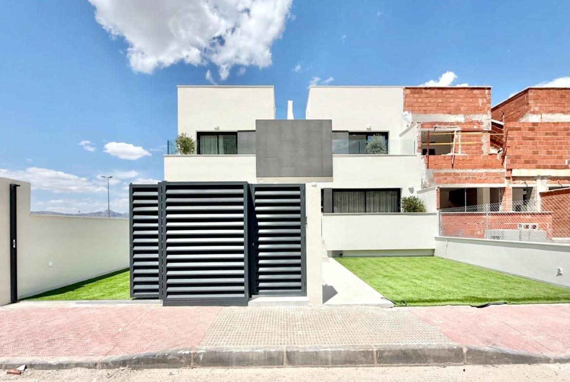 Modern, bright new build 2-bedroom townhouse exterior with manicured lawn in Cox, Alicante, part of an affordable luxury development.