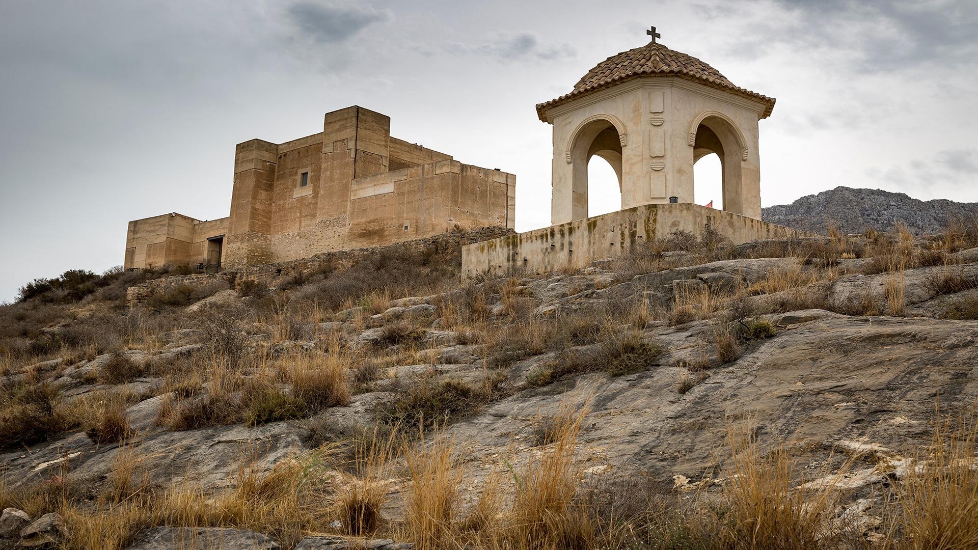 Rustic hilltop view near Cox, Alicante, featuring historic stone architecture and natural, rugged landscape background.
