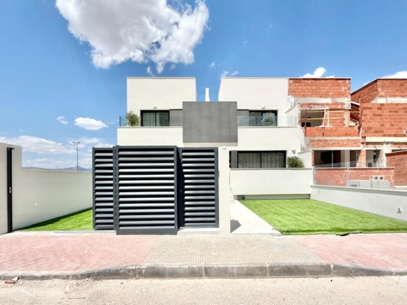 Modern spacious 3-bedroom townhouse exterior with landscaped lawn in sunny Cox, Alicante, part of new luxury build development.