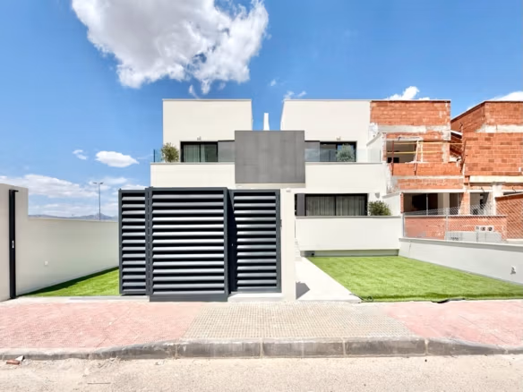 Moderne großzügige Außenansicht eines Reihenhauses mit 3 Schlafzimmern und angelegter Rasenfläche im sonnigen Cox, Alicante, Teil eines luxuriösen Neubauprojekts.