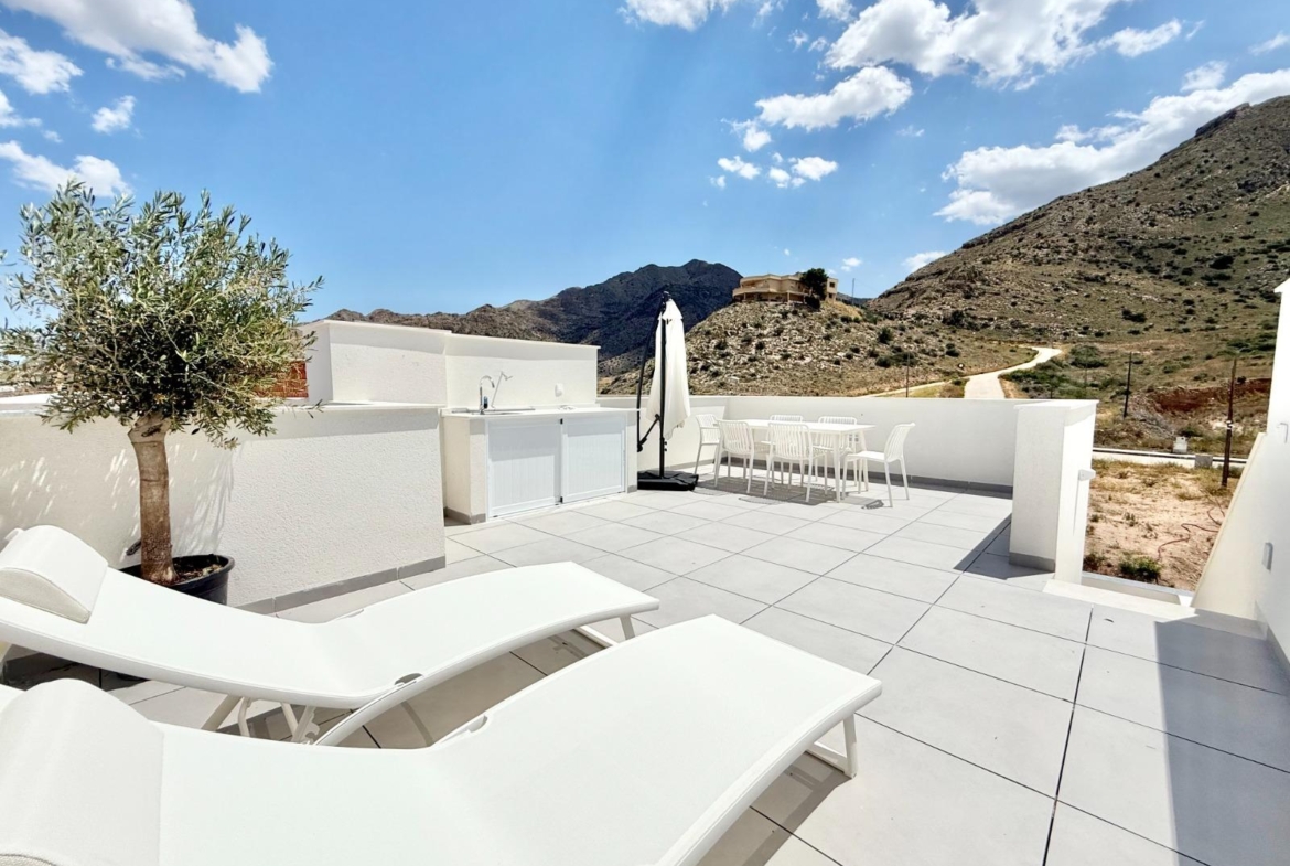 Sun-drenched solarium with modern lounge chairs and dining area in affordable new build 2-bedroom townhouse in Cox, Alicante