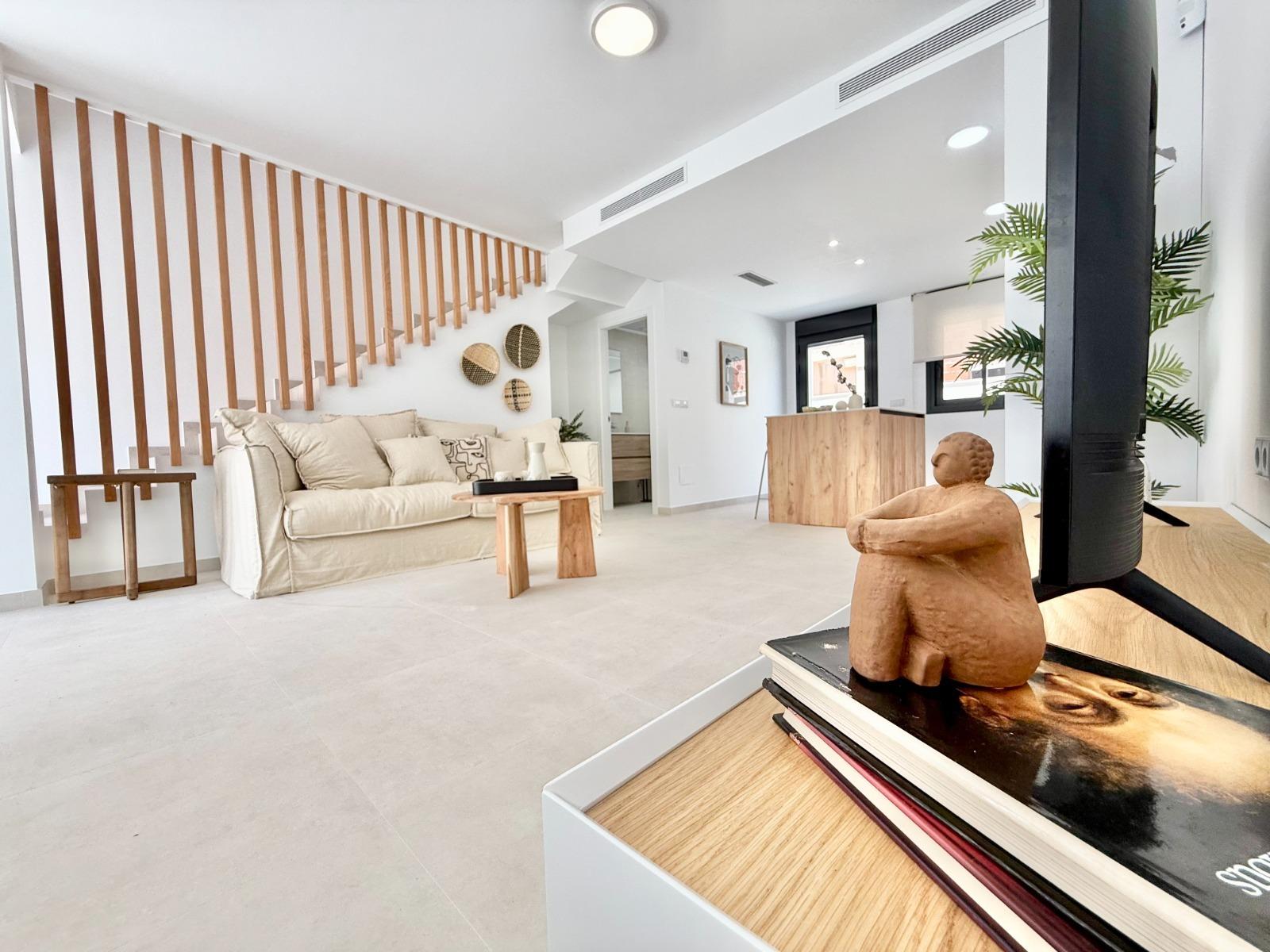 Bright modern living room with elegant wooden accents in affordable 2-bedroom Cox townhouse, Alicante new build.