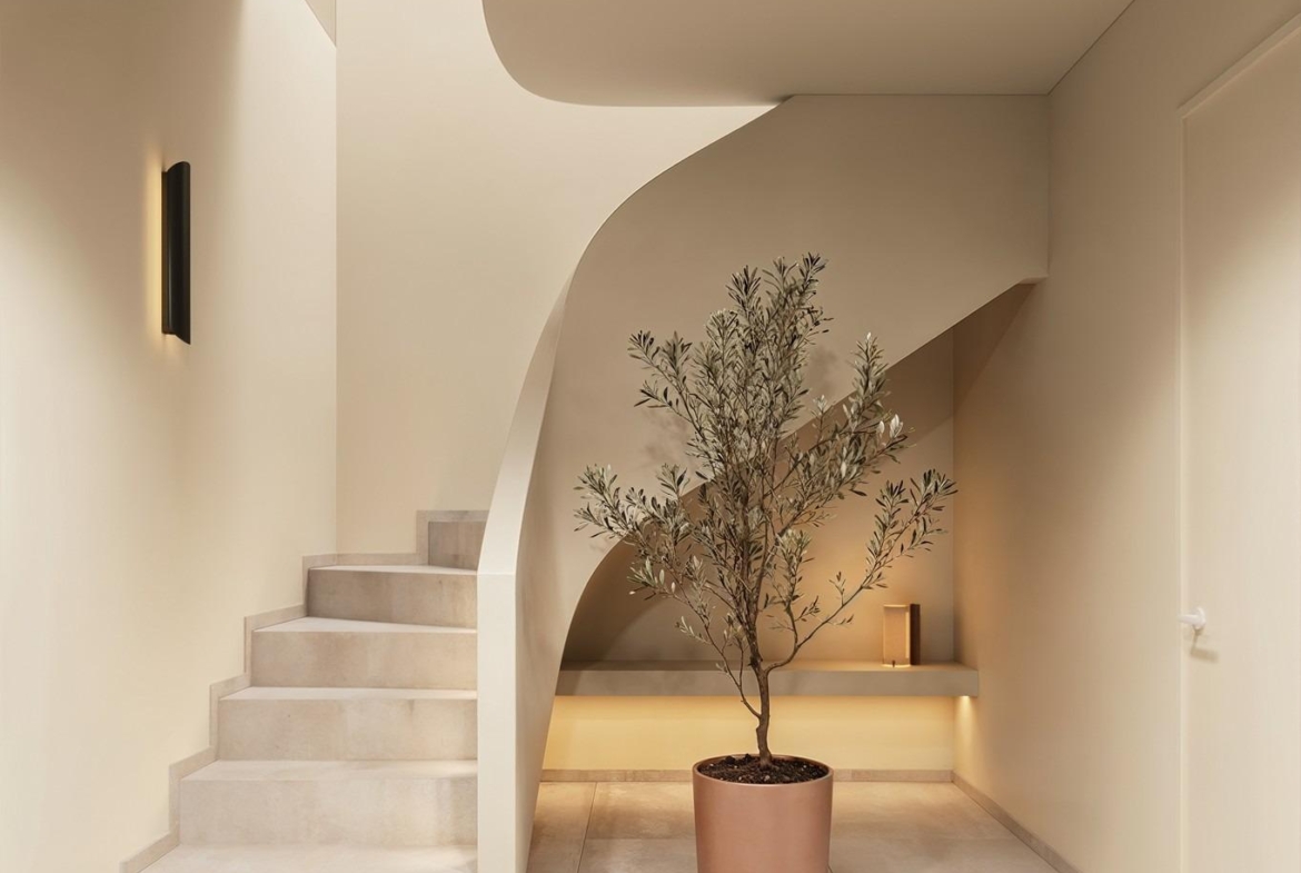 Elegant minimalist staircase with sculptural curves and soft lighting in a luxury Ibiza style villa in Algorfa, Costa Blanca.