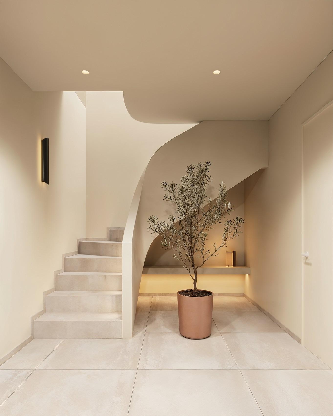 Elegant minimalist staircase with sculptural curves and soft lighting in a luxury Ibiza style villa in Algorfa, Costa Blanca.