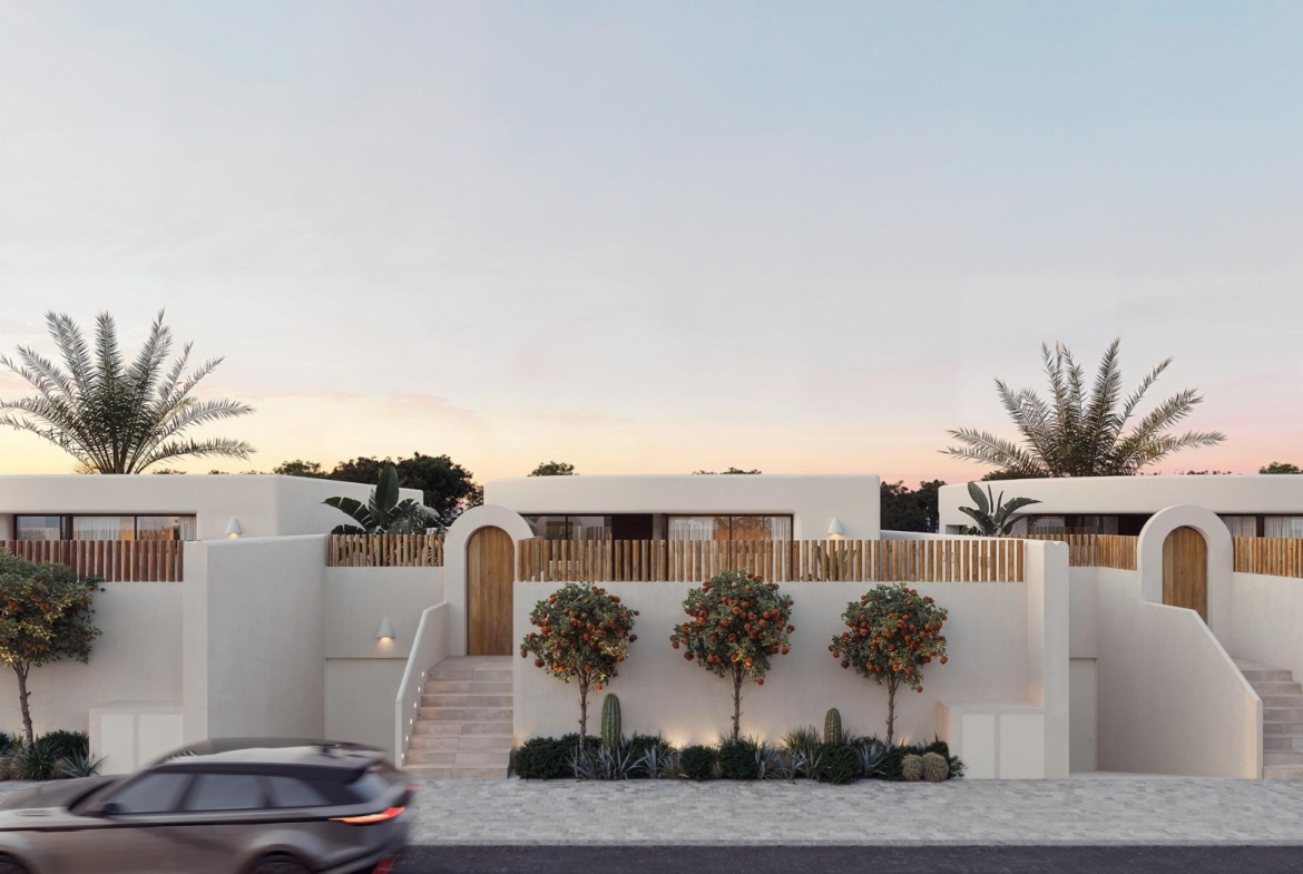 Elegant white facade of new build 4-bedroom Ibiza style villa with landscaped greenery in Algorfa, Costa Blanca at dusk.