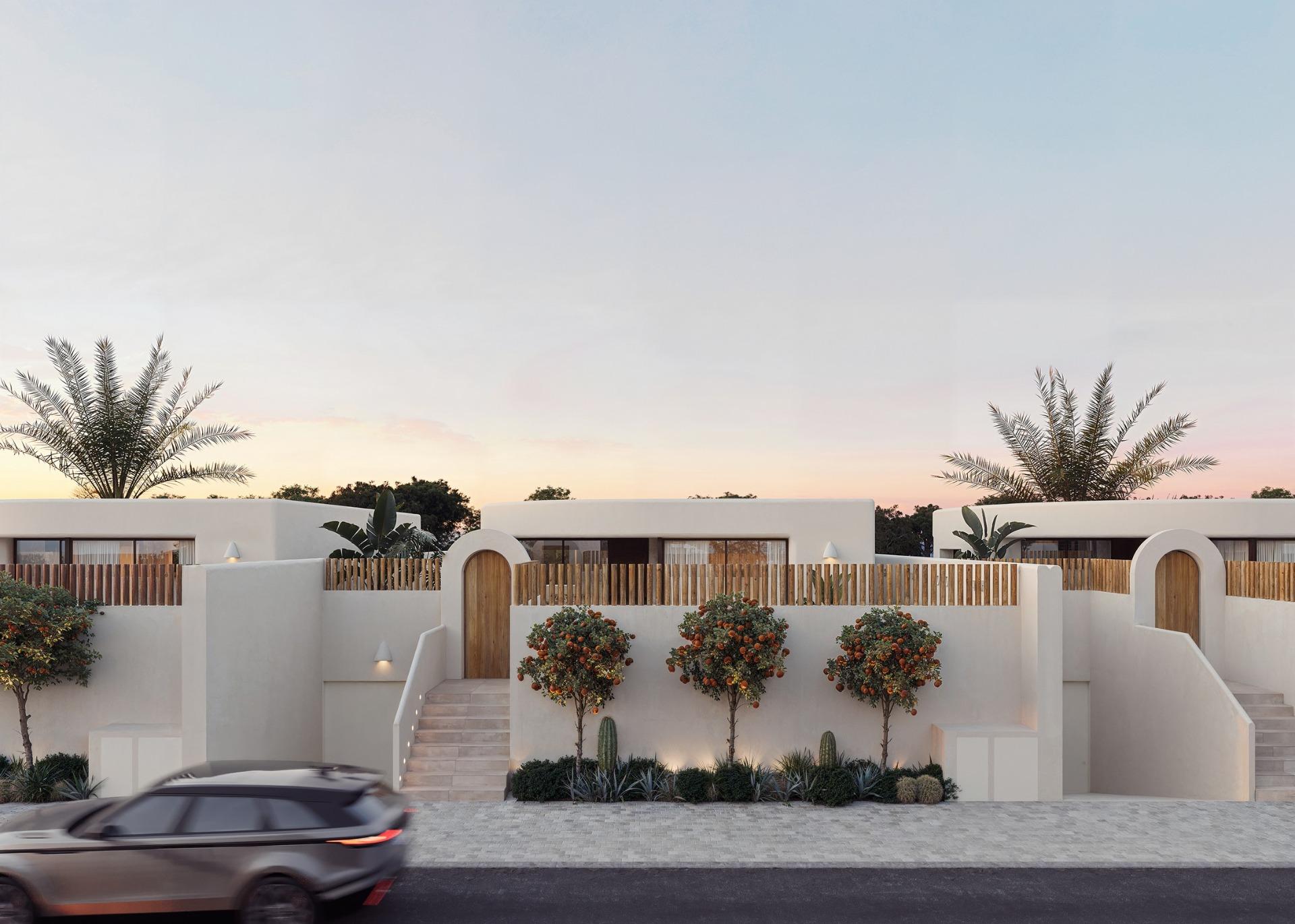 Elegant white facade of new build 4-bedroom Ibiza style villa with landscaped greenery in Algorfa, Costa Blanca at dusk.