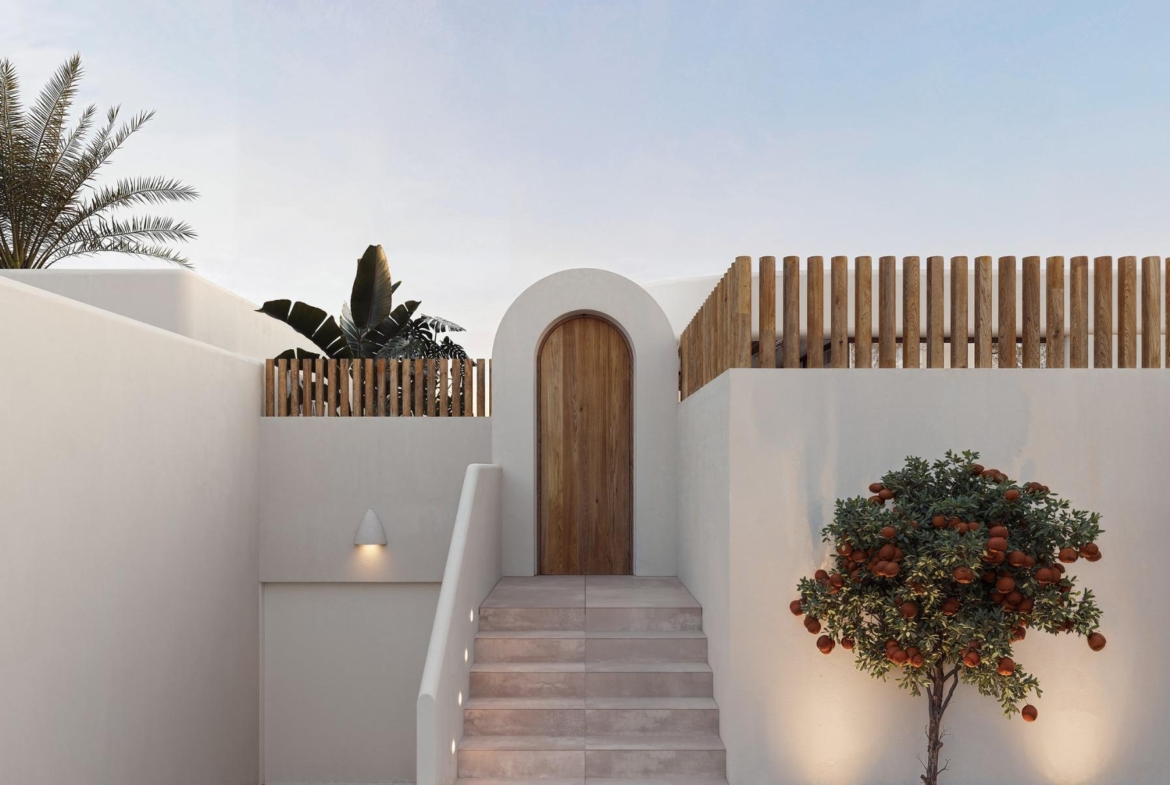 Elegant whitewashed exterior with wooden door and minimalist landscaping at 4-bedroom Ibiza style villa in Algorfa, Costa Blanca.