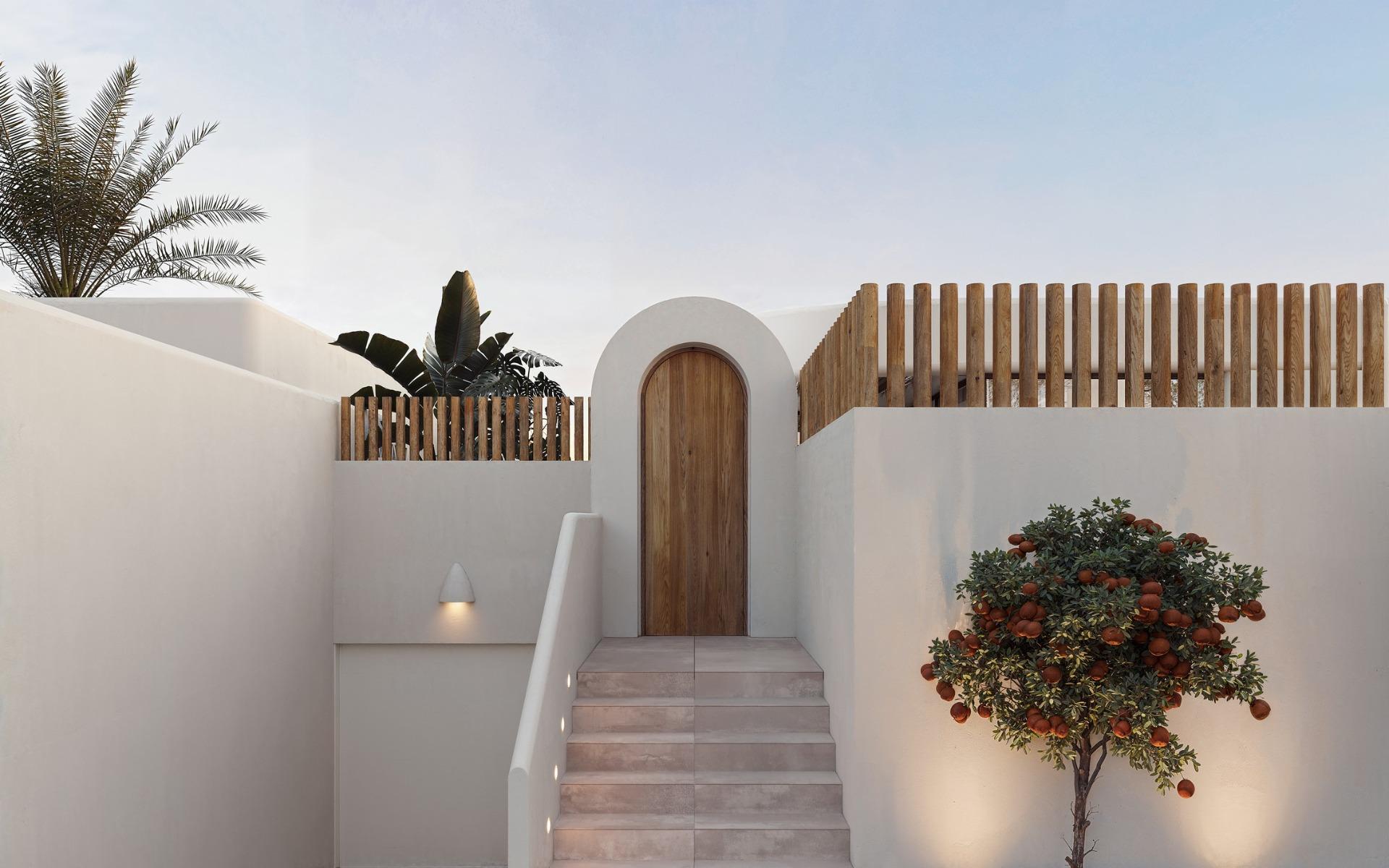 Elegant whitewashed exterior with wooden door and minimalist landscaping at 4-bedroom Ibiza style villa in Algorfa, Costa Blanca.