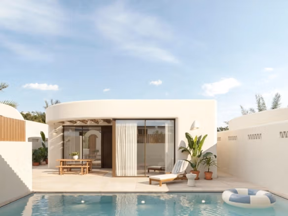 Elegante exterior de una villa de estilo ibicenco bañada por el sol, con piscina privada y terraza minimalista en La Finca Golf, Algorfa, Costa Blanca.