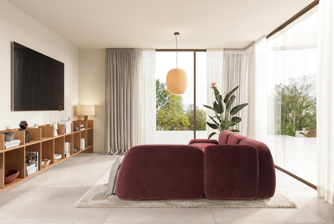 Bright and elegant living room with plush burgundy sofa and floor-to-ceiling windows in an Ibiza style villa on La Finca Golf, Algorfa.