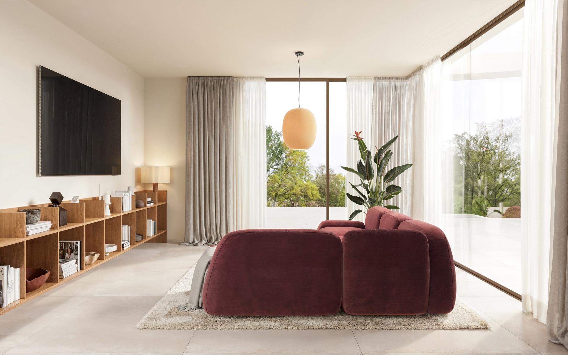 Bright and elegant living room with plush burgundy sofa and floor-to-ceiling windows in an Ibiza style villa on La Finca Golf, Algorfa.