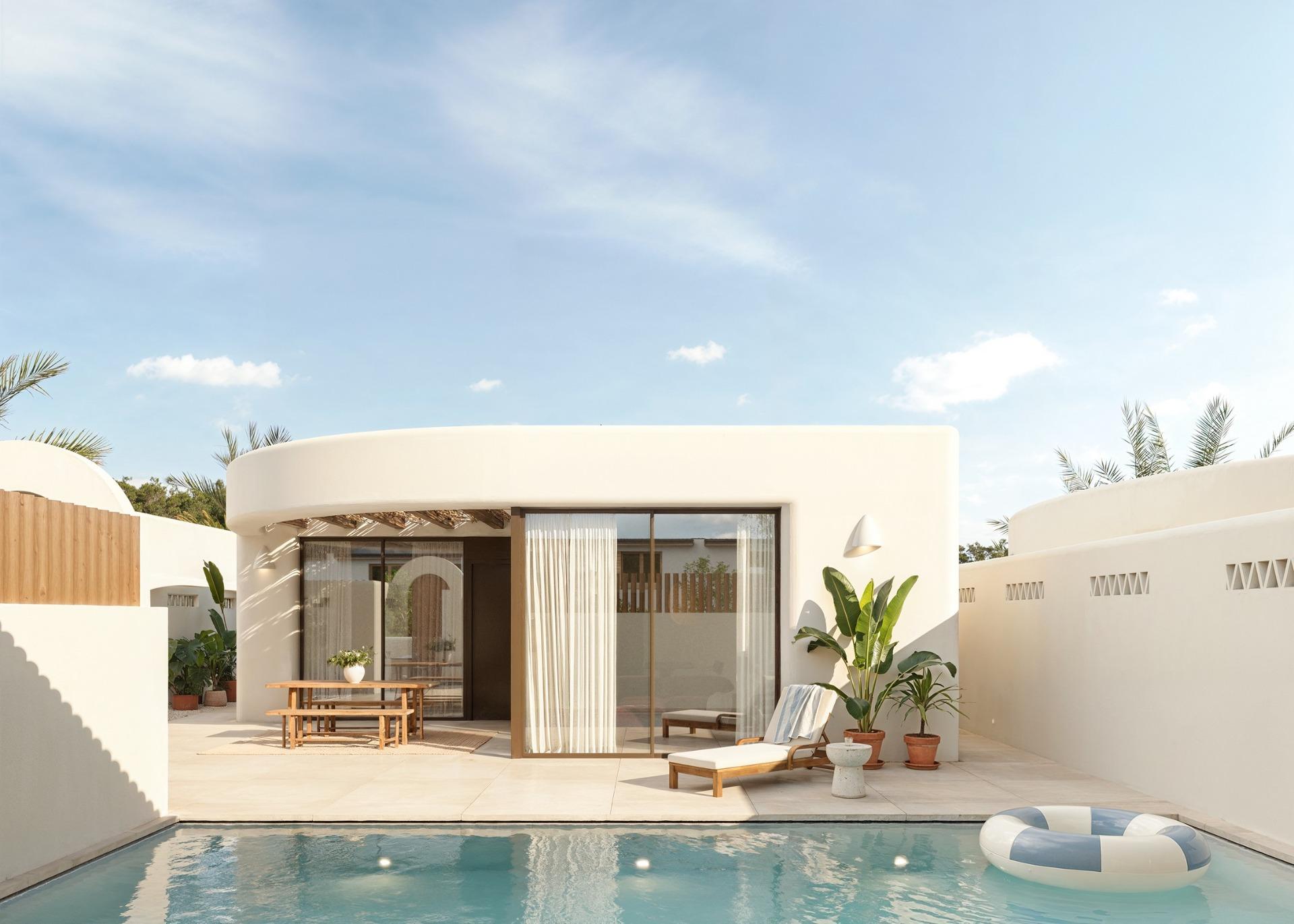 Elegant sun-drenched Ibiza style villa exterior with private pool and minimalist terrace on La Finca Golf, Algorfa, Costa Blanca.