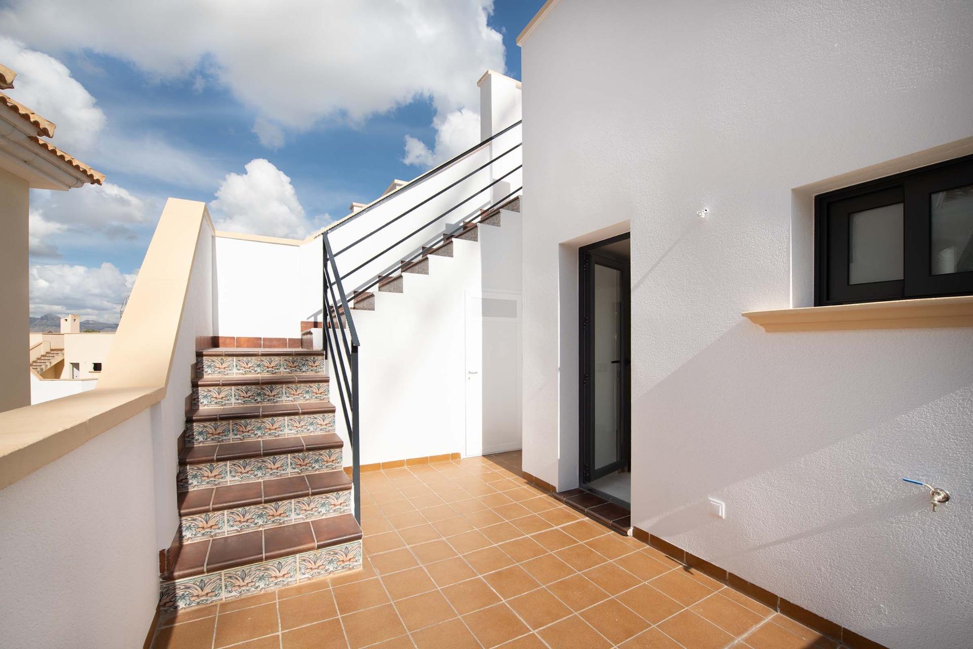 Bright sun-drenched terrace with decorative tiled stairs in a modern 2-bedroom ground floor bungalow in Cox, Alicante.
