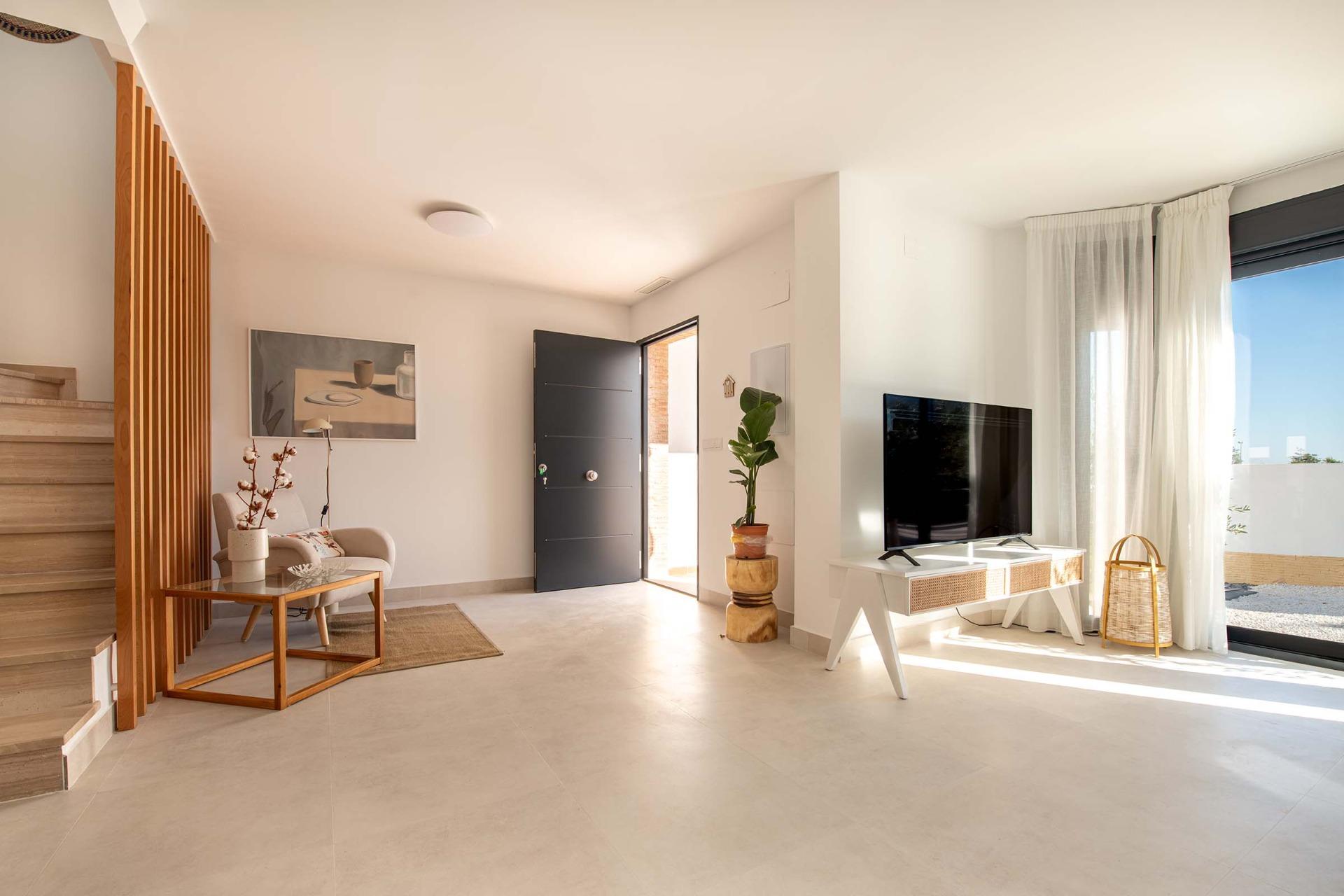 Bright modern living area with minimalist decor and terrace access in a key ready 2-bedroom bungalow in Cox, Alicante.