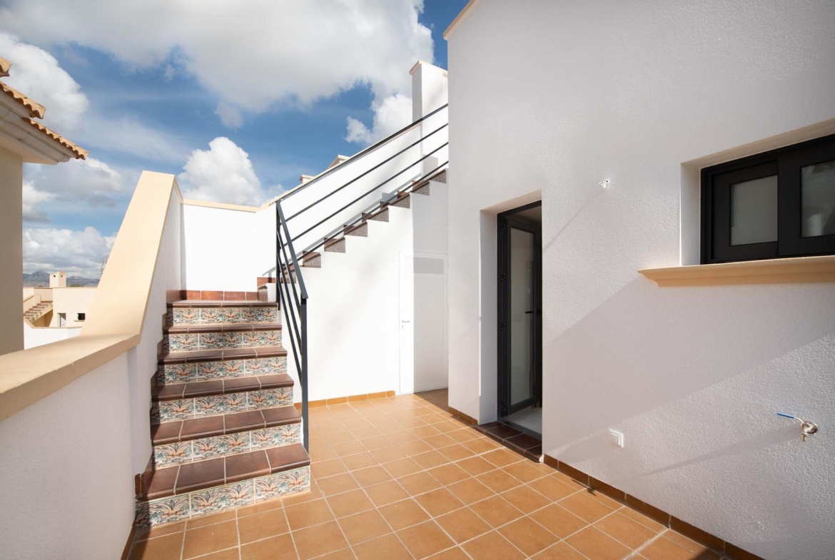 Bright sun-drenched terrace with decorative tiled stairs and modern white façade in 3-bedroom townhouse, Cox, Alicante.