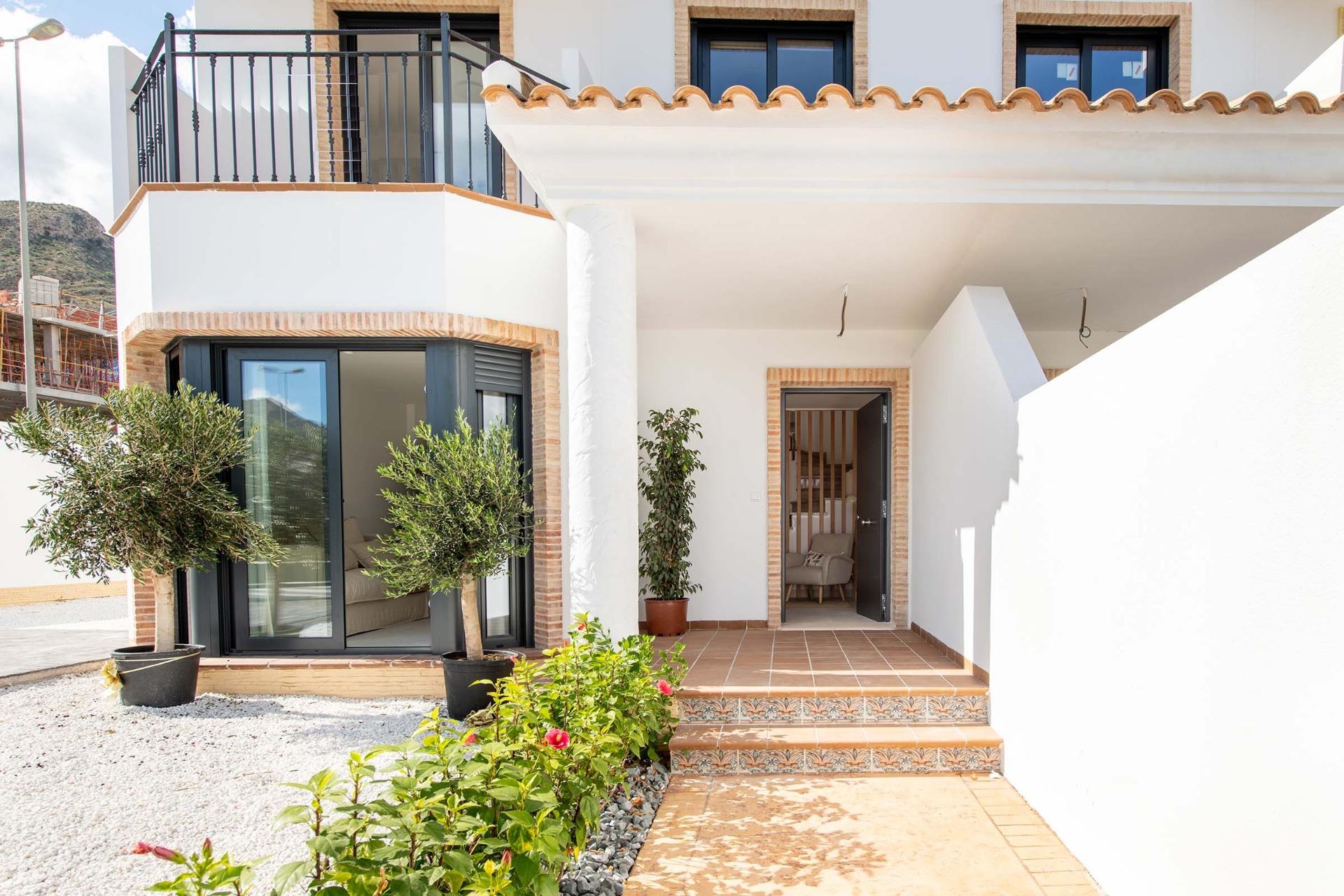 Bright modern top floor bungalow exterior with terracotta tile steps and lush plants in Cox, Alicante.