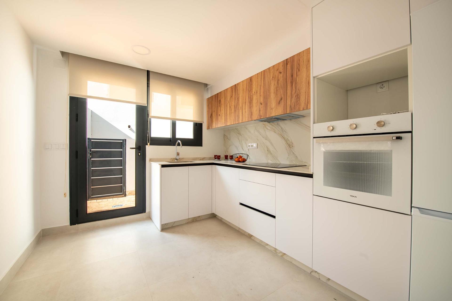 Bright modern kitchen with sleek white and wood cabinetry in spacious 3-bedroom ground floor bungalow, Cox, Alicante.