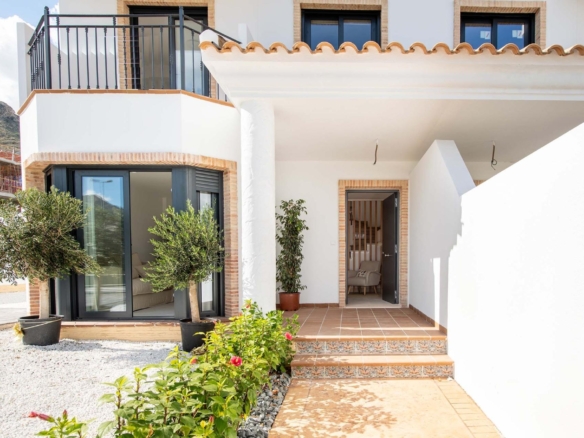 Bright modern exterior of a 3-bedroom townhouse in Cox, Alicante, featuring elegant tiled steps and lush greenery.