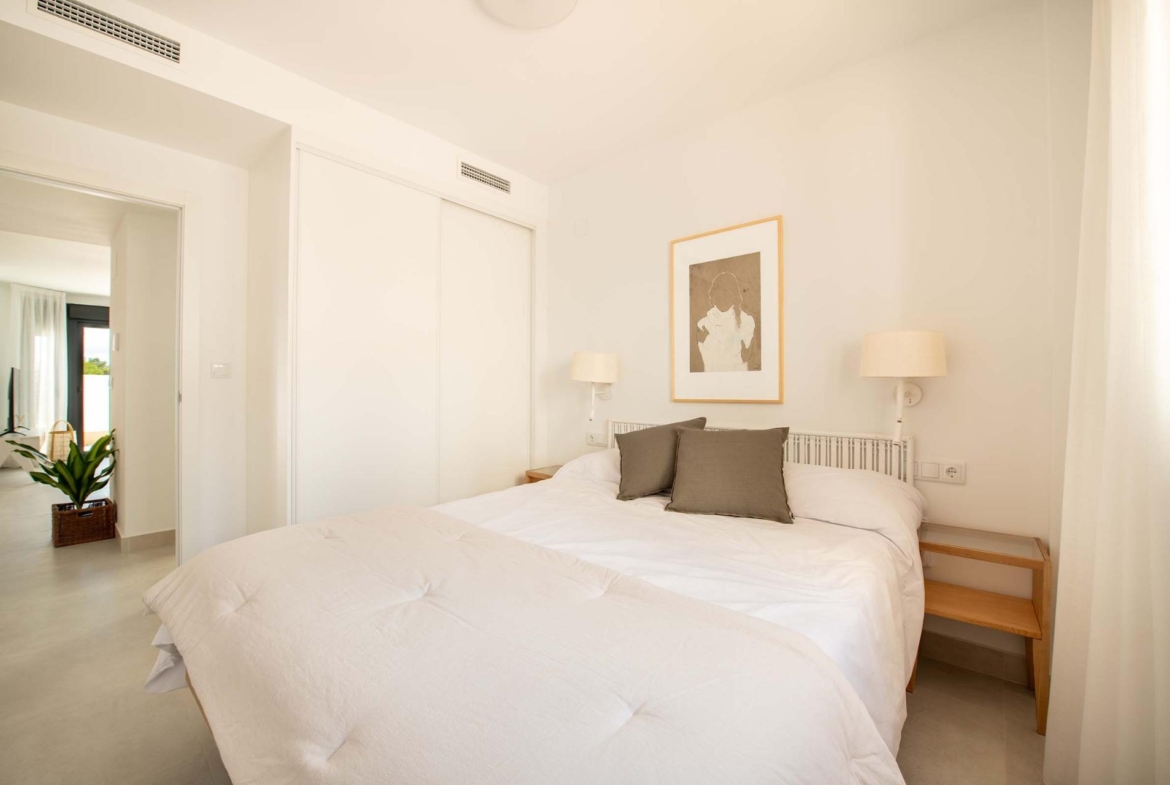 Bright modern bedroom with crisp white linens in a top-floor 2-bedroom bungalow in Cox, Alicante.