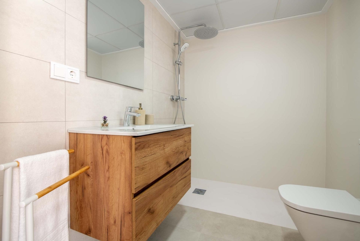 Modern, sleek bathroom with wood vanity and walk-in shower in 2 bedroom top floor bungalow, Cox, Alicante.