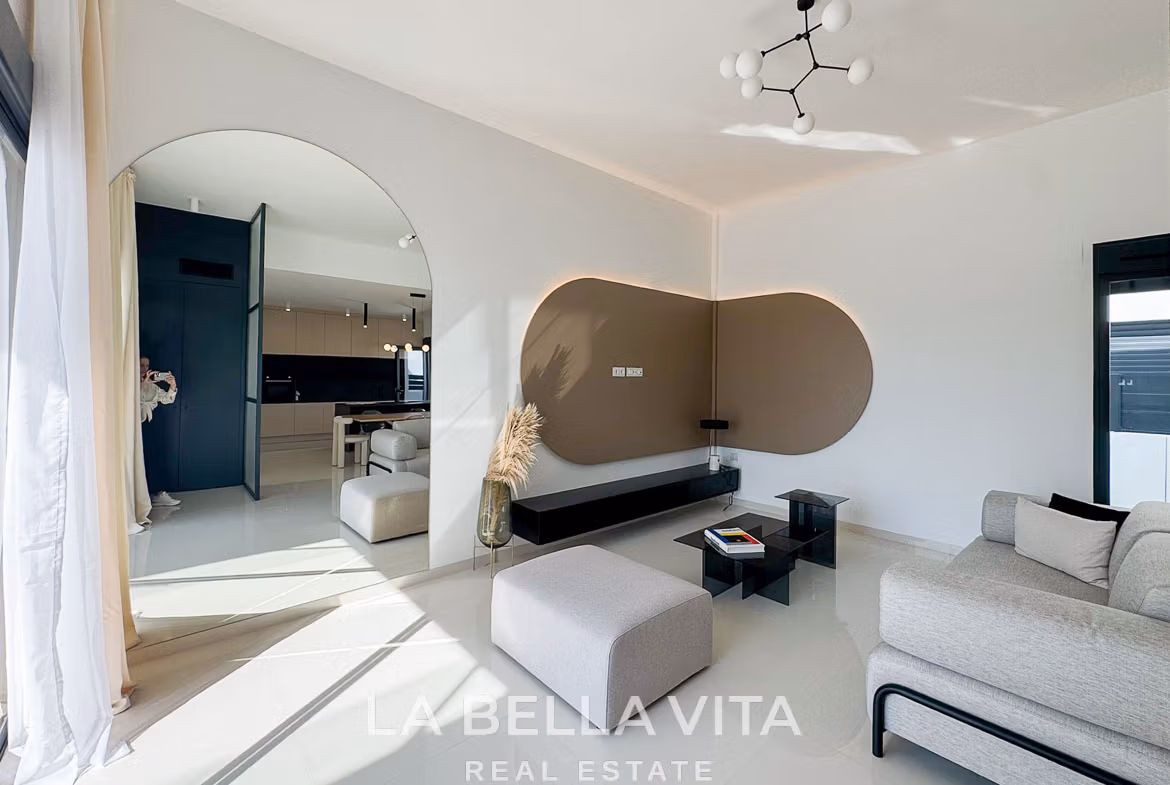 Bright, modern living room with sleek furniture and open archway in a 3-bedroom villa in San Miguel de Salinas.