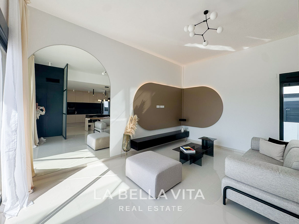 Bright, modern living room with sleek furniture and open archway in a 3-bedroom villa in San Miguel de Salinas.