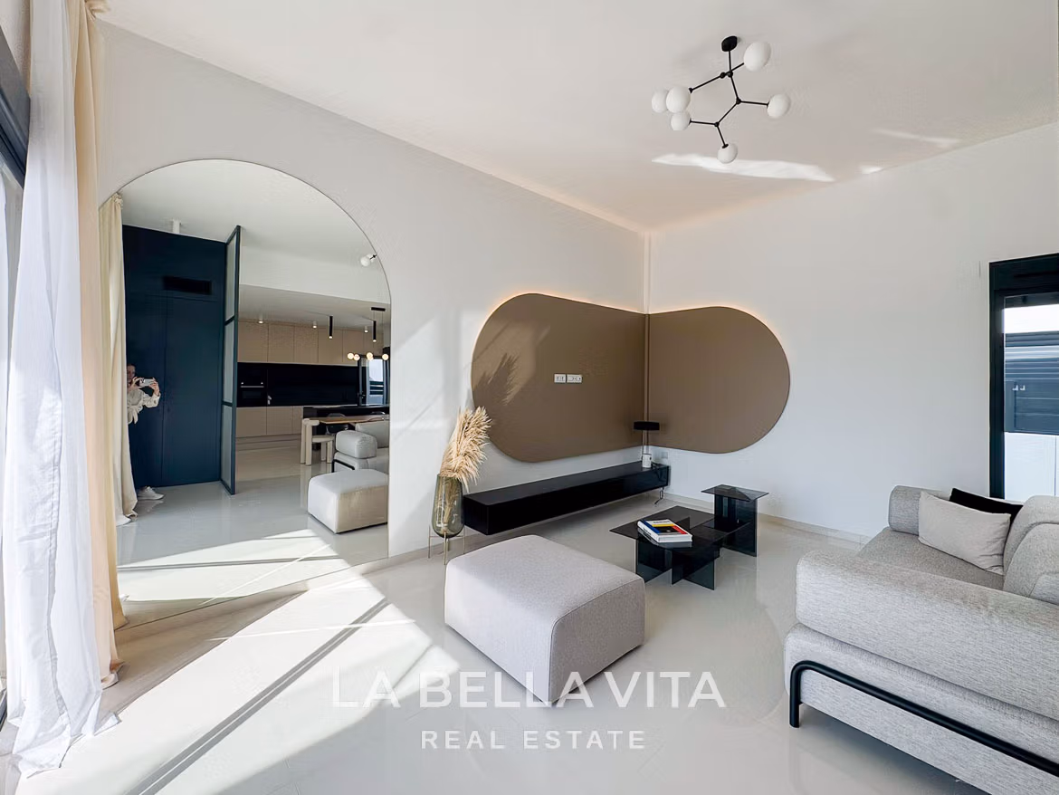 Bright, modern living room with sleek furniture and open archway in a 3-bedroom villa in San Miguel de Salinas.
