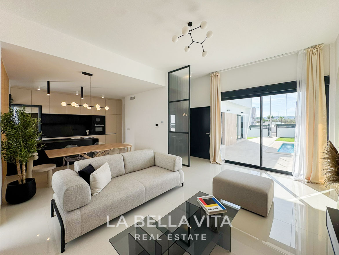 Bright, modern open-plan living area with sleek kitchen and glass doors opening to private pool terrace in San Miguel de Salinas villa.