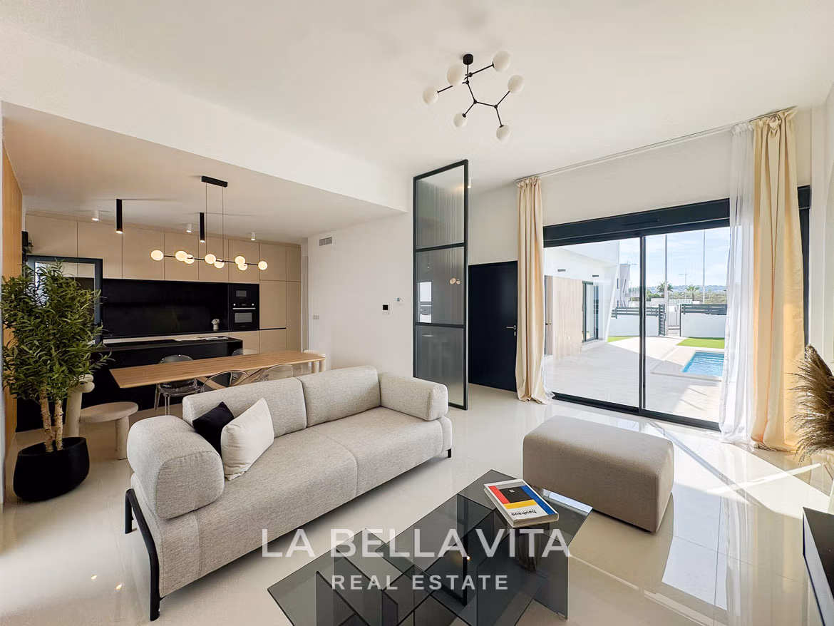 Bright, modern open-plan living area with sleek kitchen and glass doors opening to private pool terrace in San Miguel de Salinas villa.