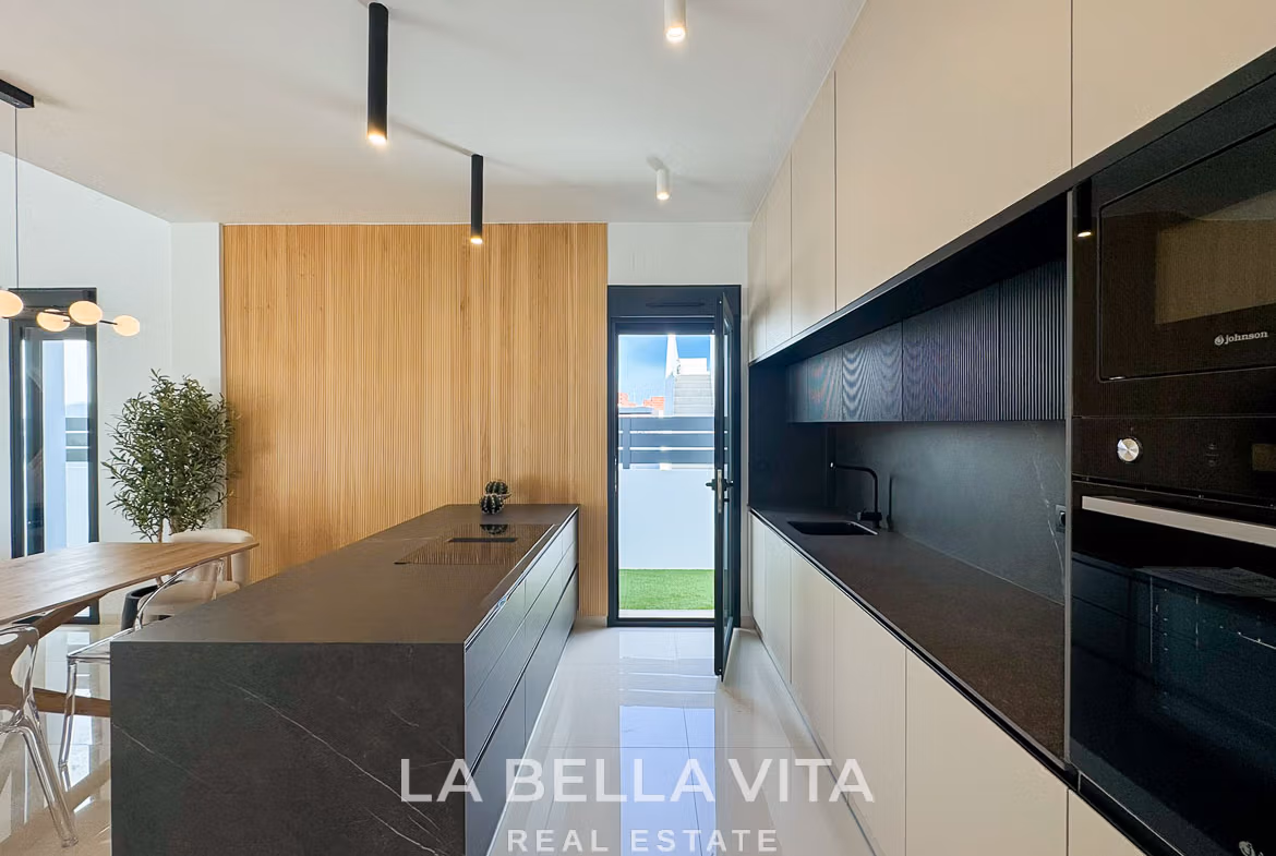 Bright modern kitchen with sleek black island and light wood accents in 3 bedroom villa in San Miguel de Salinas