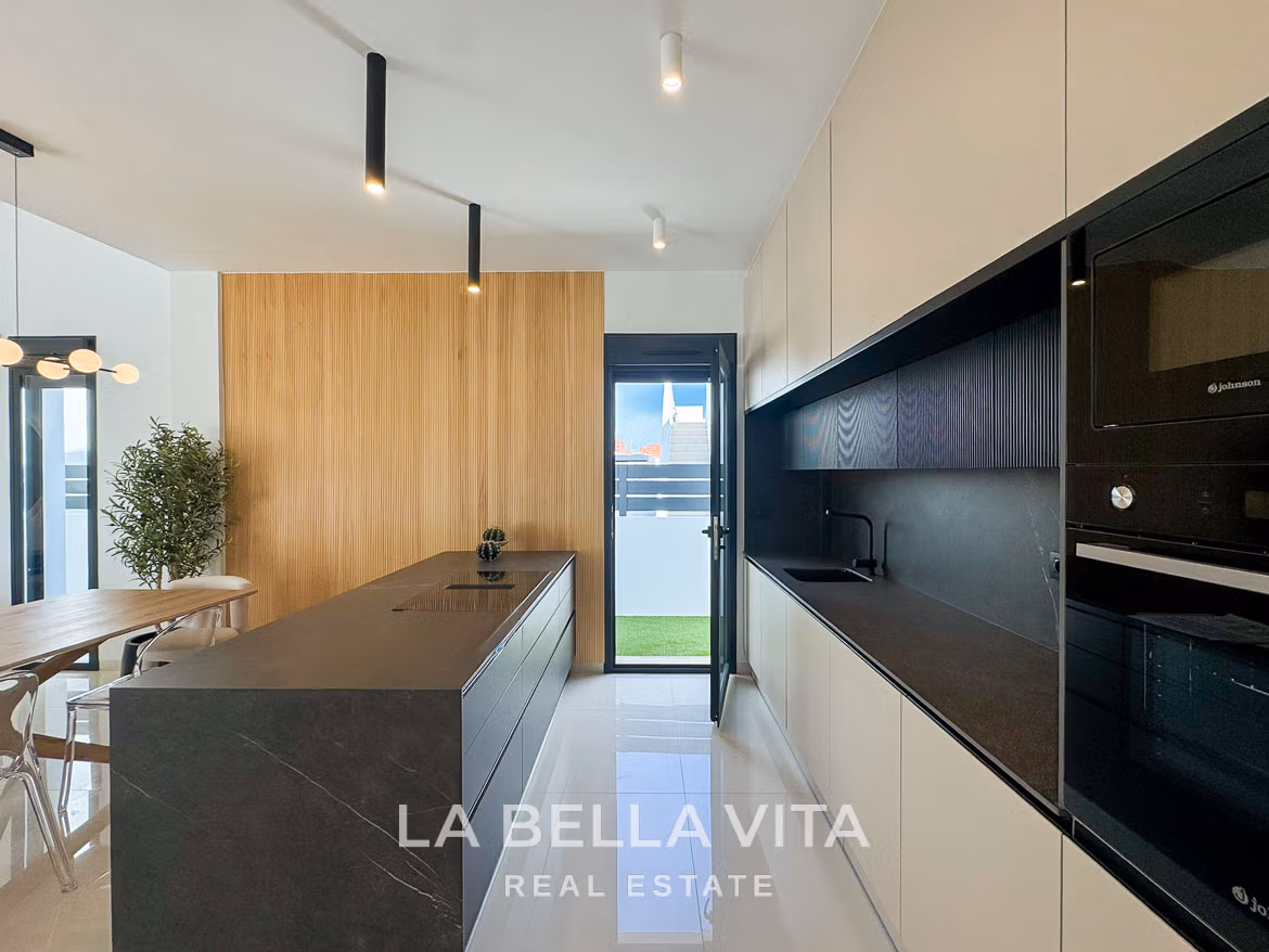 Bright modern kitchen with sleek black island and light wood accents in 3 bedroom villa in San Miguel de Salinas