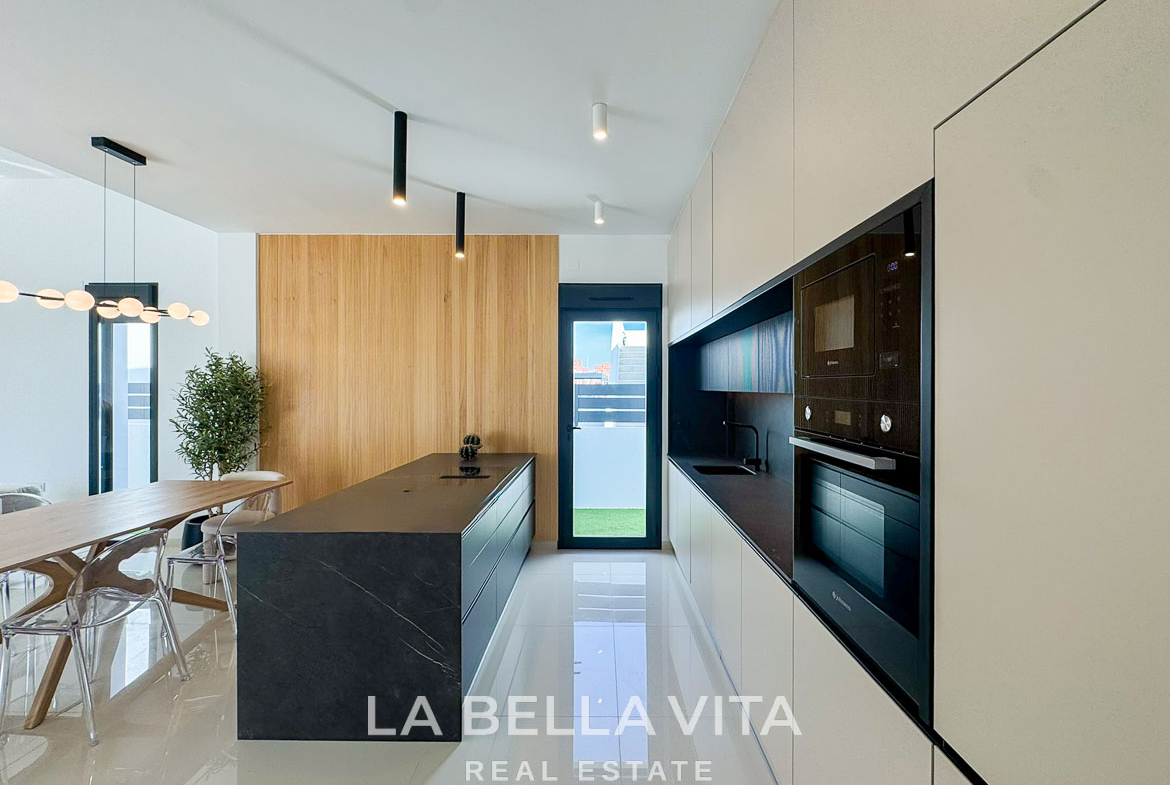 Sleek modern kitchen with black island and elegant wood paneling in a luxury 3-bedroom villa in San Miguel de Salinas.